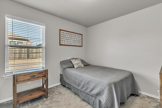 bedroom featuring baseboards and light carpet