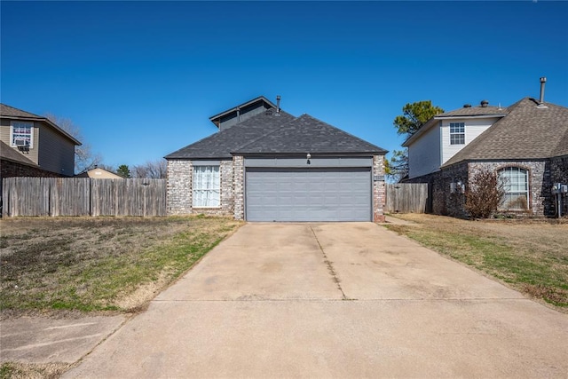 view of front of property with brick siding, concrete driveway, a front yard, fence, and a garage