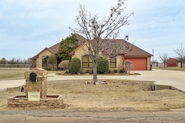 french provincial home with a garage and driveway