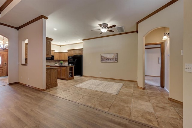 kitchen featuring visible vents, brown cabinets, black appliances, arched walkways, and ceiling fan