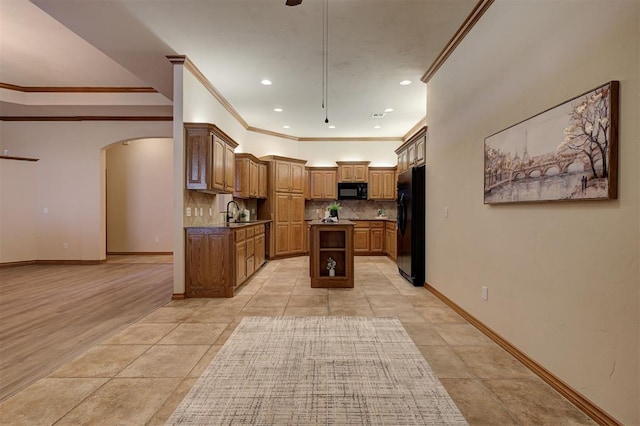 kitchen with a center island, baseboards, decorative backsplash, arched walkways, and black appliances