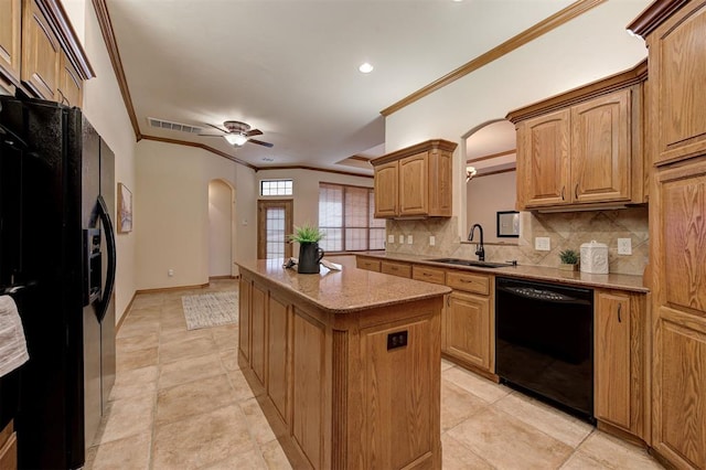 kitchen featuring visible vents, black appliances, a sink, a center island, and arched walkways