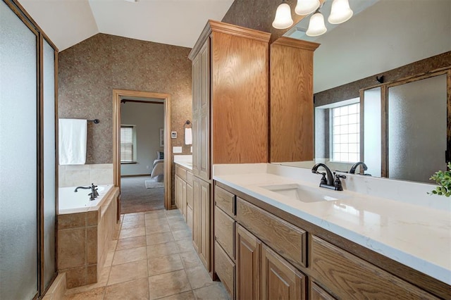 bathroom with tile patterned floors, vaulted ceiling, a bath, a notable chandelier, and vanity