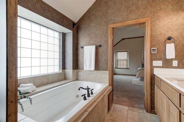 ensuite bathroom with tile patterned floors, ensuite bathroom, vanity, lofted ceiling, and a whirlpool tub