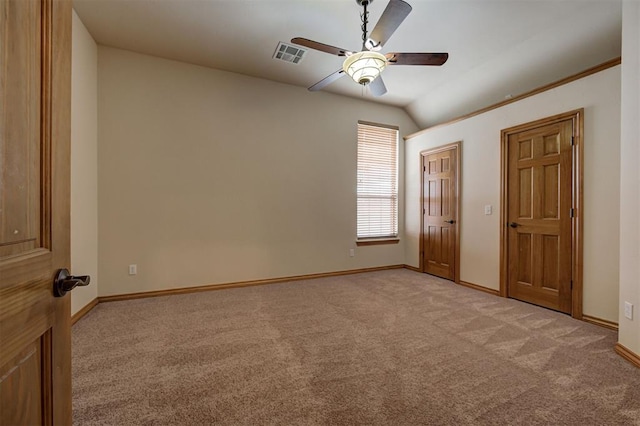 unfurnished bedroom with visible vents, light carpet, a ceiling fan, baseboards, and lofted ceiling