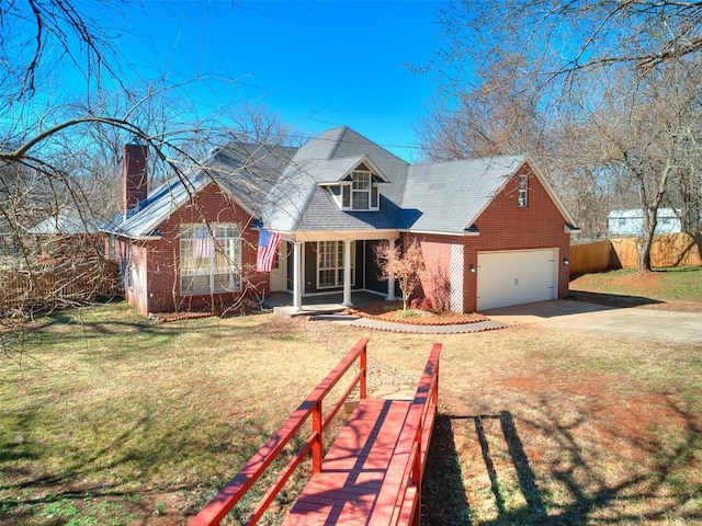 view of front of property with driveway, brick siding, covered porch, fence, and a front yard