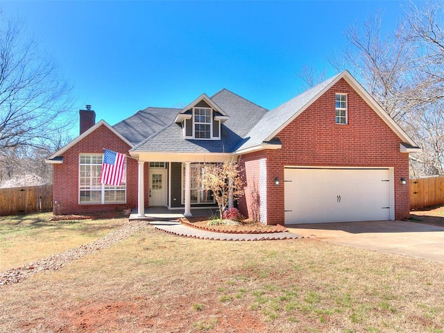 traditional-style home featuring concrete driveway, a porch, a front yard, and fence