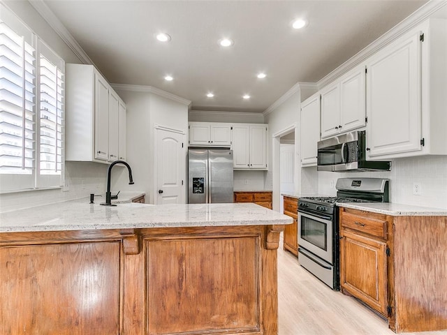 kitchen featuring stainless steel appliances, backsplash, light wood-style floors, ornamental molding, and a peninsula