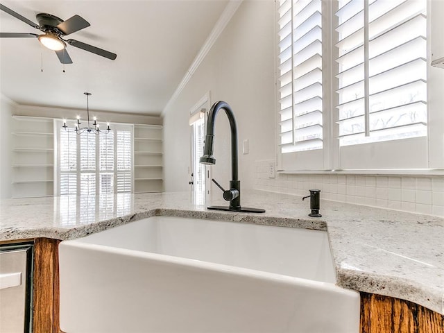 interior details featuring light stone counters, a sink, backsplash, dishwasher, and crown molding