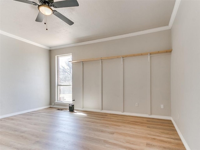 unfurnished bedroom featuring light wood-style floors, a ceiling fan, baseboards, and crown molding