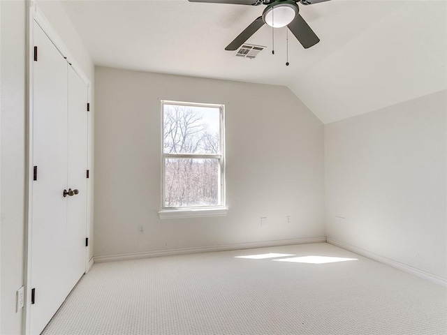 additional living space featuring ceiling fan, light colored carpet, visible vents, baseboards, and vaulted ceiling