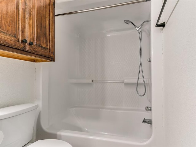 bathroom with bathtub / shower combination and toilet