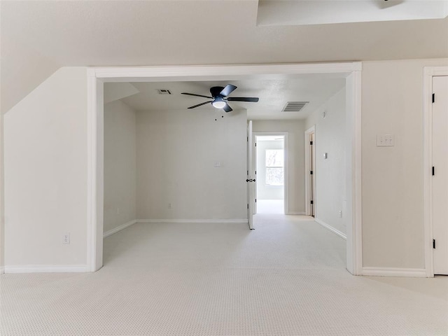 spare room with light carpet, visible vents, and baseboards