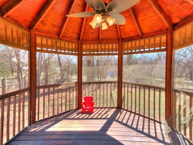 unfurnished sunroom featuring wooden ceiling, vaulted ceiling with beams, and ceiling fan