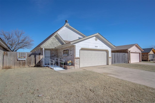 view of front of house featuring brick siding, a chimney, an attached garage, fence, and driveway