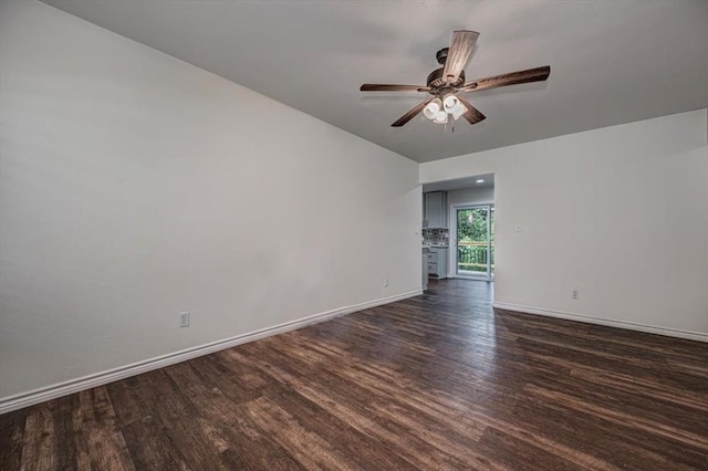 unfurnished room with dark wood-style floors, ceiling fan, and baseboards