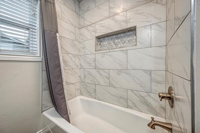 bathroom featuring shower / tub combo and a textured wall