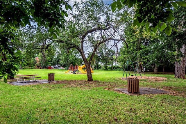 view of property's community with a lawn and playground community