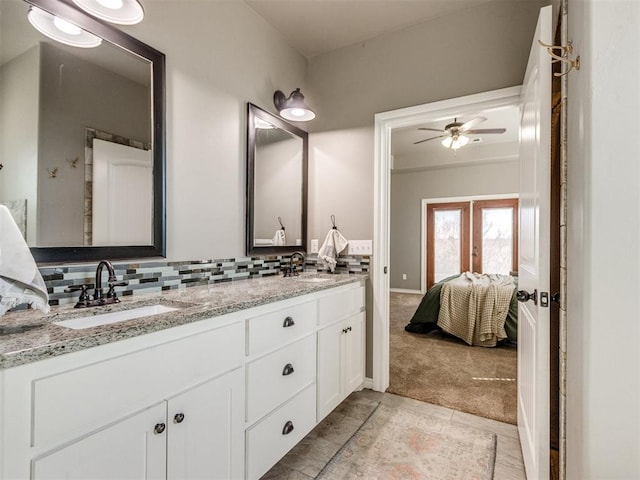 bathroom with a sink, decorative backsplash, ensuite bath, and double vanity