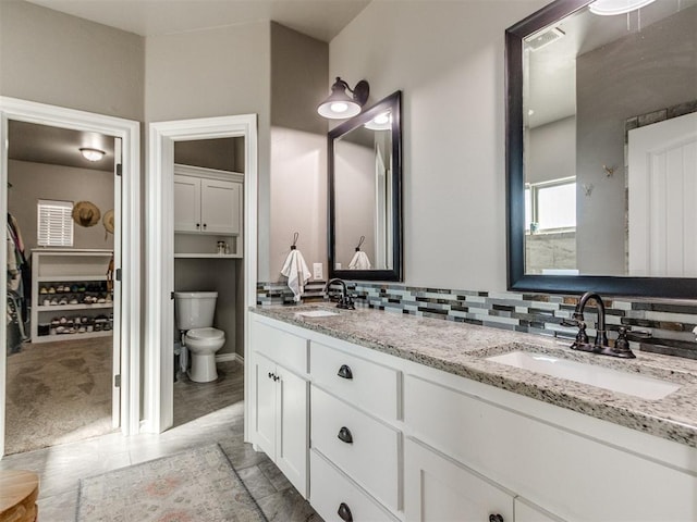 full bath with double vanity, decorative backsplash, visible vents, and a sink