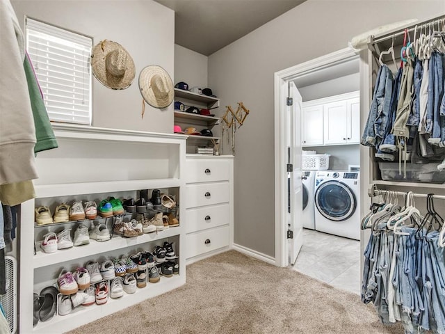 laundry area featuring cabinet space, separate washer and dryer, and light carpet