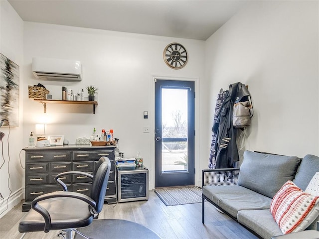 home office featuring light wood finished floors and a wall mounted air conditioner