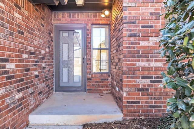 doorway to property featuring brick siding