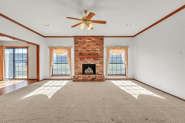 unfurnished living room featuring carpet, a brick fireplace, plenty of natural light, and baseboards