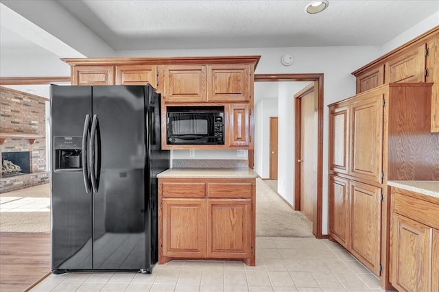 kitchen featuring black appliances, light countertops, and brown cabinets