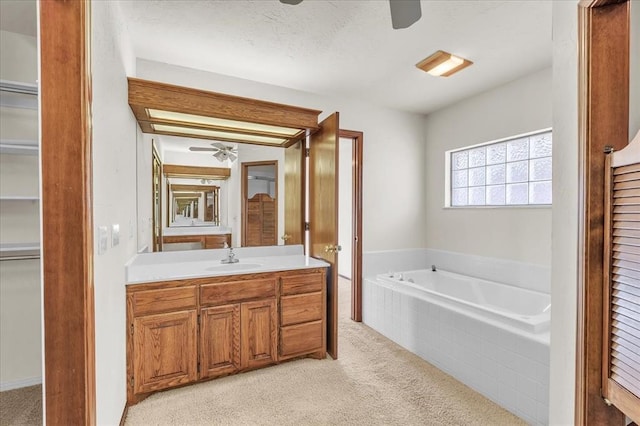 bathroom featuring a closet, carpet, vanity, and a bath