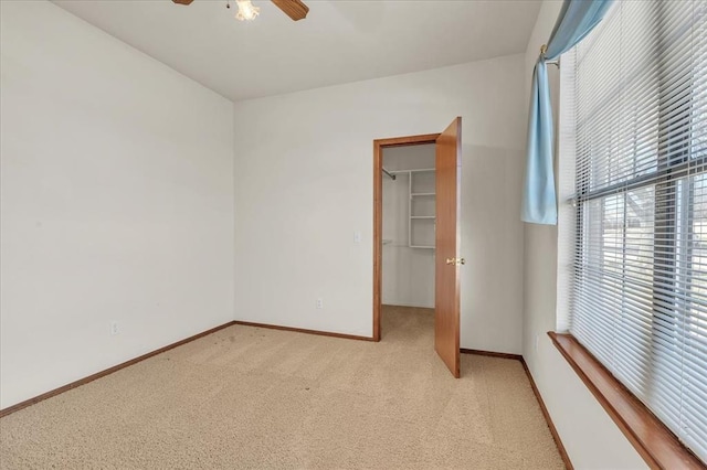 unfurnished room featuring baseboards, a ceiling fan, and light colored carpet