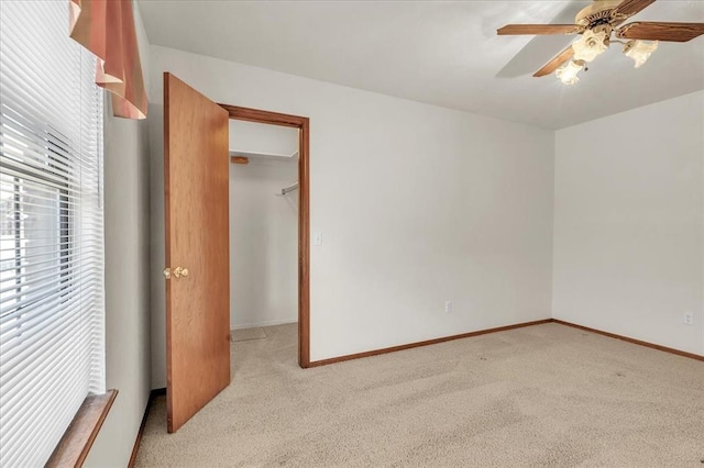 unfurnished bedroom featuring ceiling fan, baseboards, and light colored carpet