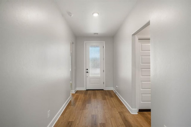 entryway with light wood finished floors and baseboards