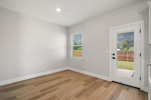 entryway featuring baseboards and light wood finished floors