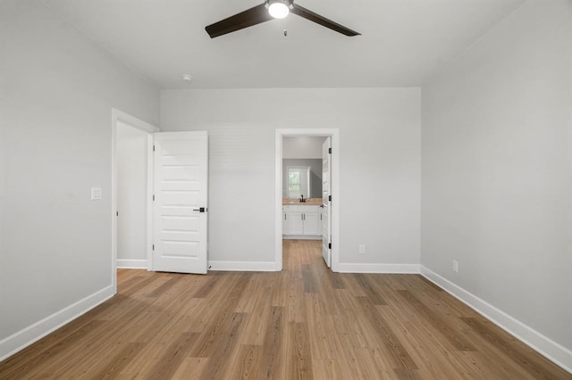 unfurnished bedroom with ceiling fan, light wood-type flooring, ensuite bath, and baseboards