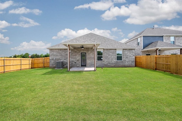 back of house with a fenced backyard, central AC, a ceiling fan, and a lawn