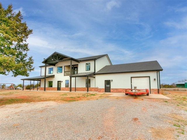 view of front of home with brick siding, a standing seam roof, metal roof, a garage, and driveway