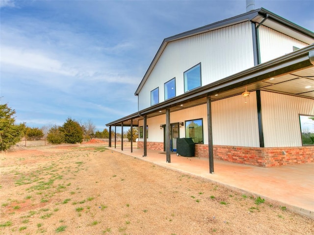 back of property with a patio area and brick siding