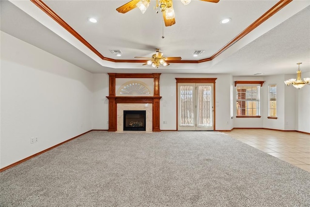 unfurnished living room featuring carpet, visible vents, a tray ceiling, and ornamental molding