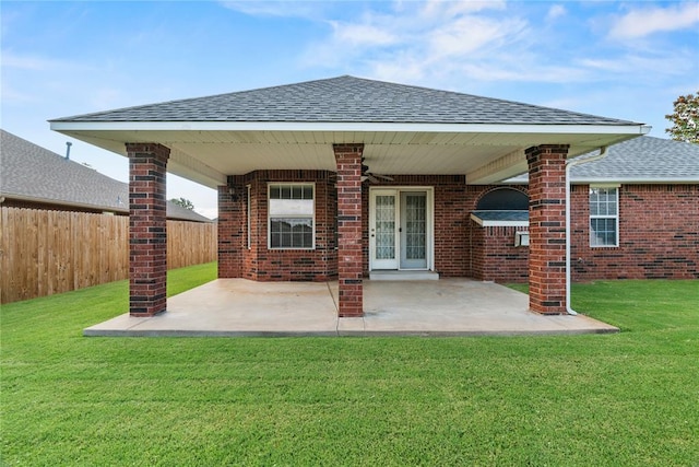 501 N Cherokee Way, Mustang, OK 73064 - back of property featuring a shingled roof, a ceiling fan, brick siding, and a patio area