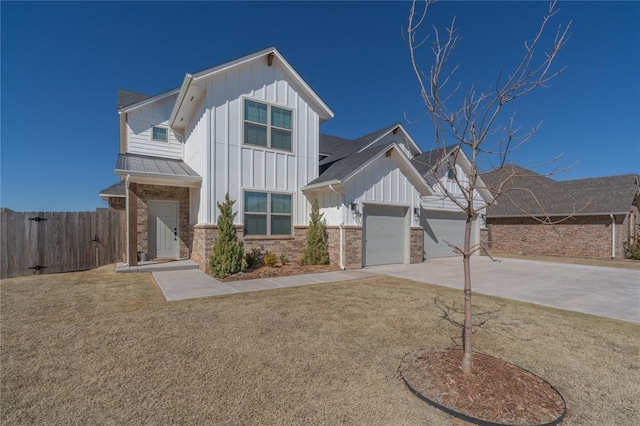 modern farmhouse featuring an attached garage, fence, concrete driveway, a front lawn, and board and batten siding