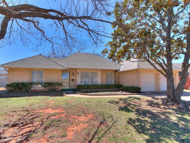 ranch-style home with roof with shingles, brick siding, a front lawn, and an attached garage