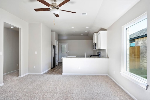 kitchen with carpet floors, visible vents, appliances with stainless steel finishes, white cabinets, and baseboards