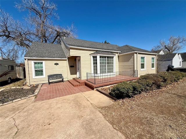 view of front of house featuring a patio area and a shingled roof