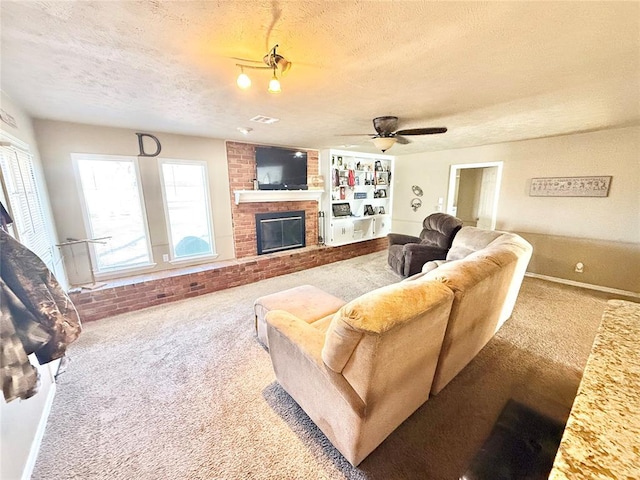 living room with a ceiling fan, a brick fireplace, carpet flooring, and a textured ceiling