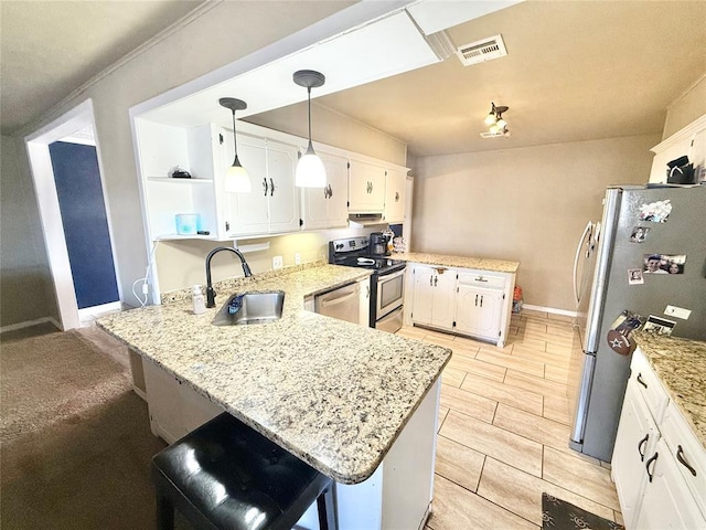 kitchen with visible vents, white cabinets, a peninsula, stainless steel appliances, and a sink