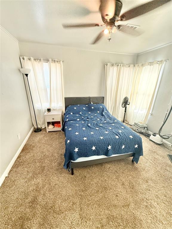 carpeted bedroom with a ceiling fan and baseboards