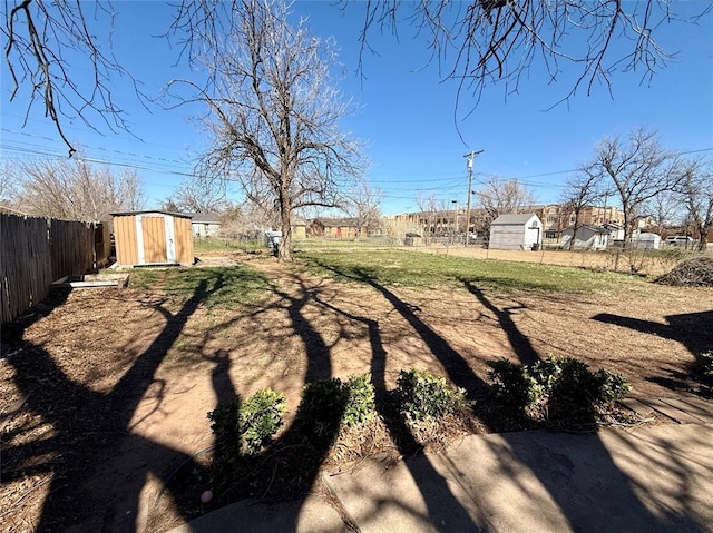 view of yard with a storage shed, a fenced backyard, and an outdoor structure