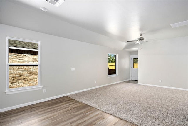 spare room with visible vents, ceiling fan, light wood finished floors, and baseboards