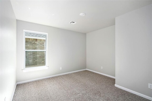 empty room featuring carpet, visible vents, and baseboards